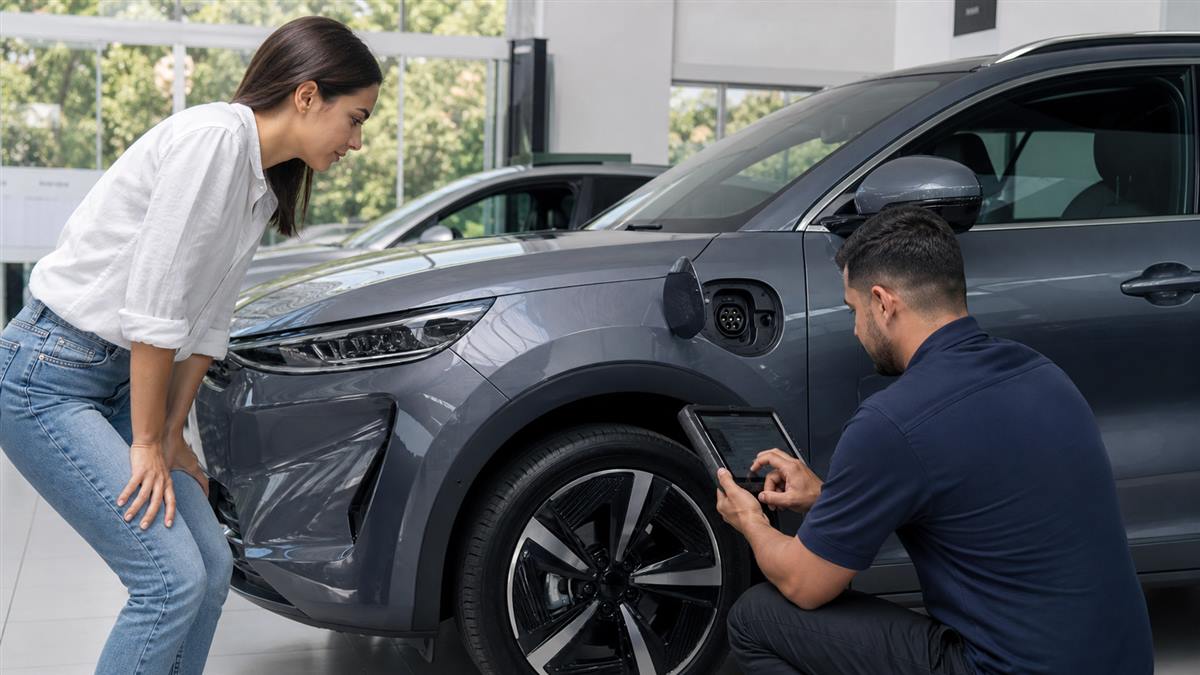 Compradora e técnico inspecionam um carro elétrico usado